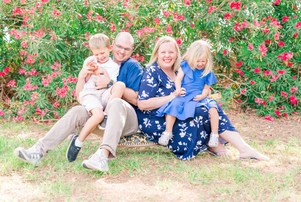 Mom and Dad prepped kids for family session. Family of four sitting on the floor smiling, playing games and tickling each other in Las Cruces, New Mexico.
